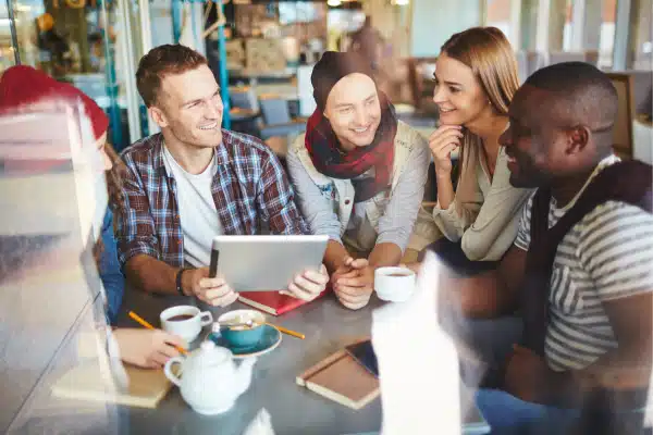 Group of young adults chatting at a table happily